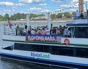 Feiernde MEnschen auf dem Deck des Schiffs MS Rheinland auf dem Rhein.